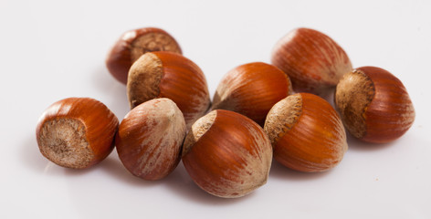 Fototapeta premium Unpeeled hazelnut on white surface closeup