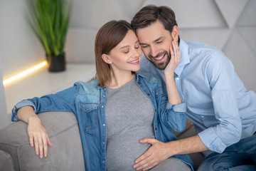 Young pregnant woman feeling happy with her husband