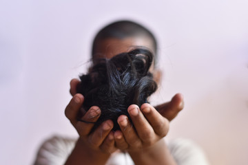 indian boy cut hair in a boy hand with blur background, stay home and life during lockdown in India 