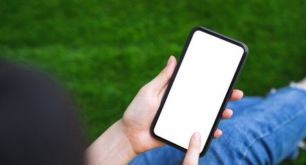 Mock up of woman hand holding smartphone and touching blank screen.