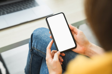 Mock up of woman hand holding smartphone and touching blank screen.