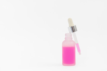 Fototapeta na wymiar Pipette with collagen moisturizing hyaluron serum with pink liquid in a light matt bottle with pipette isolated on grey background. 