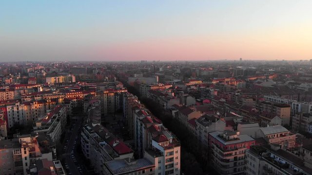 Drone aerial view of Milan skyline from above during sunset time in residential area. Shot in Lambrate area during Coronavirus lockdown quarantine. Moving backward and sideways.