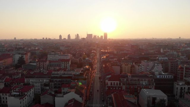 Drone aerial view of Milan skyline from above with colourful sunset over the city. Shot in Lambrate area during Coronavirus lockdown quarantine. Moving forward.