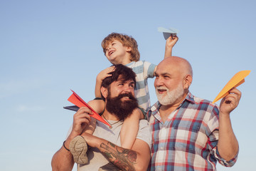 Grandfather with son and grandson having fun in park. Fathers day concept. Cute child hugging his...