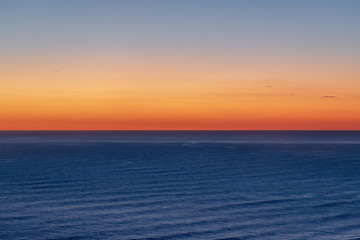 Naklejka na ściany i meble Aerial view of bright sunset sky over Tasman sea horizon