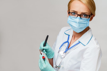 medical doctor nurse woman wearing protective mask and gloves - making mark by pen on virus blood test tube