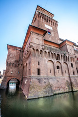 Fototapeta na wymiar The Castello Estense in Ferrara in Italy. Moated medieval castle in the center of Ferrara, northern Italy. It consists of a large block with four corner towers.