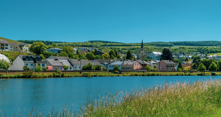 Beautiful German town with church tower on the Moselle river - Nittel, Germany
