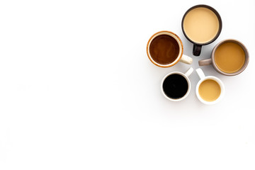 Different cups of coffee on white table top-down space for text