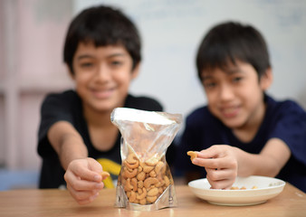 Little boys eating cashew nut healthy snack time