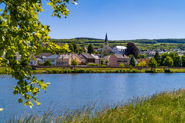 Fototapeta premium The Beautiful town of Nittel in Germany with church tower on the Moselle river