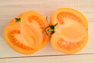 Ripe juicy yellow tomatoes on a painted white table.