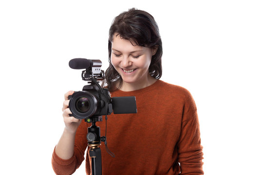 Female art student studying to be a filmmaker using a camera on a tripod for a project. She looks confident about her creativity. Depicts entertainment industry production and education