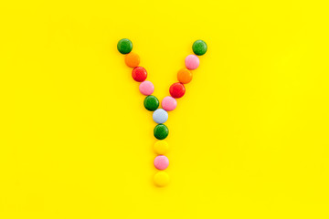 Letter Y - alphabet made with sweets on yellow from above