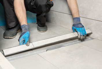 A worker is installing a drain lid.