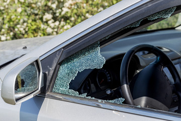 Criminal incident. Hacking a car. Broken driver's side window of car. Thieves smashed window of car...