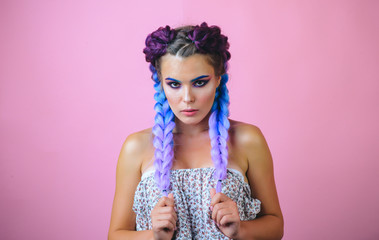 Fototapeta premium Kanekalon strand in braids. Girl with two pigtails, portrait of a fashion girl with braids. Beautiful braids. Braided hairstyle concept. Girls with braided hair style.