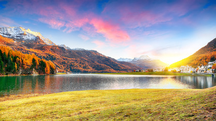 Stunning autumn panorama of Silvaplana lake and village at sunset