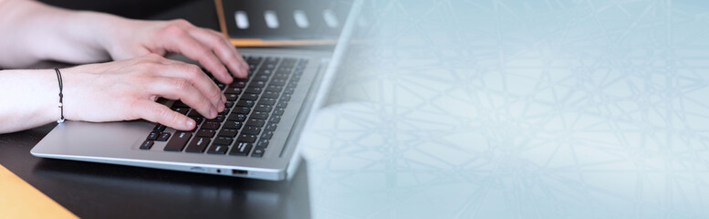 Female hands working on laptop; panoramic banner