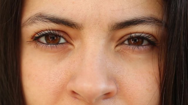 Woman opening eyes looking to camera, macro close-up female eye staring to lens