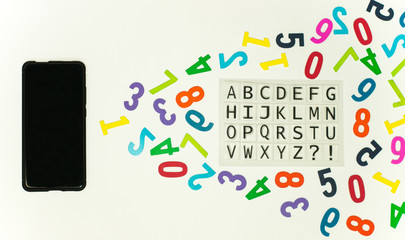 Smartphone que proyecta números de colores y un alfabeto latín en fondo blanco. 
