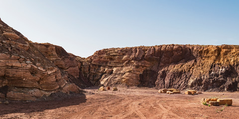 limestone layers dominate the left and middle of this abandoned quarry in the Ramon Crater in Israel while various clay deposits are found on the right third of the image