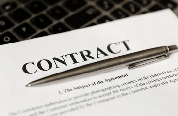 Pen for signing the contract. The pen and contract are on the laptop.