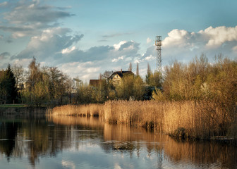 Jezioro, trzciny budynek w oddali, maszt, wieża. chmury © Krzysztof