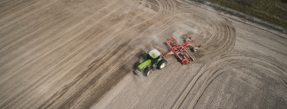 Farmers Cultivating. Tractor Makes Vertical Tillage. Aerial View