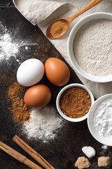 Fototapeta na wymiar Ingredients for baking on a culinary background. Eggs, flour, cinnamon, sugar, soda on the kitchen table. Concept of preparation for baking. The view from the top