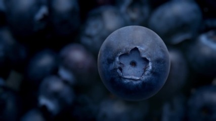 super slow motion 120 fps top view of blueberry falling down to blueberries on background