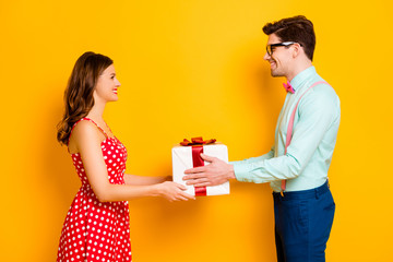 Profile photo of pretty lady handsome guy couple boyfriend giving girlfriend big gift box 8 march present wear red dotted dress shirt bowtie pants isolated yellow bright color background