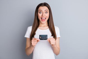 Portrait of astonished positive girl hold credit card impressed easy baking service payment wear...