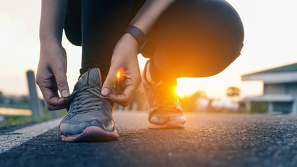 Running shoes tying shoe laces. Closeup of fitness getting ready for engage running jogging outdoors