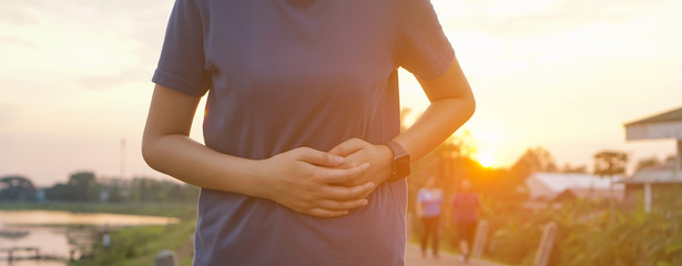 stomach ache concept. Sport injury, stomach ache after running and exercise outside in summer.