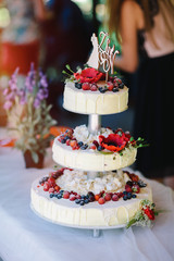 White wedding cake with flowers and berries