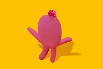 Life of rubber glove - protective wear isolated on yellow studio background with copyspace for ad. Must have during pandemic, epidemic, for protection and cleaning. Funny look from the inside.