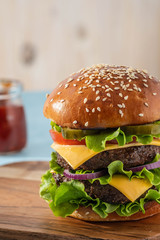 Big sandwich - hamburger burger with beef, tomato, cheese, pickled cucumber and red onion.