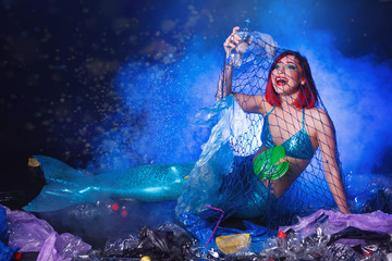 Obraz na płótnie Canvas Ocean plastic pollution. Mermaid have fun in water with plastic garbage. Stop plastic pollution. Fairy tale and reality concept.