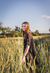 Junge Frau in Feld während Sonnenuntergang