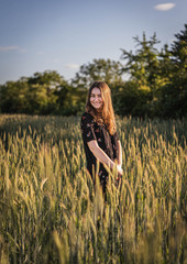 Junge Frau in Feld während Sonnenuntergang