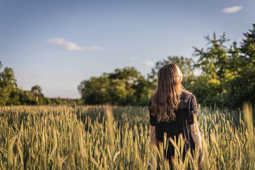 Junge Frau in Feld während Sonnenuntergang