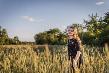 Junge Frau in Feld während Sonnenuntergang
