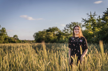 Junge Frau in Feld während Sonnenuntergang