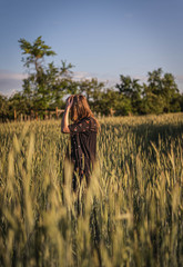 Junge Frau in Feld während Sonnenuntergang