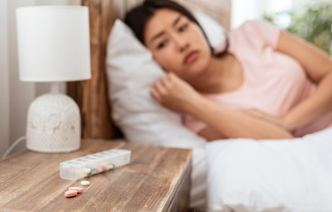 Obraz na płótnie Canvas Asian Girl Taking Sleeping Pills Having Insomnia Lying In Bed