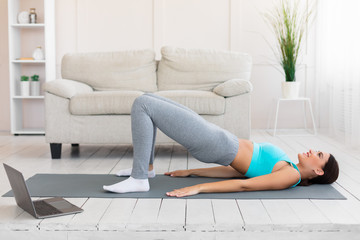 Fitness Woman Doing Pilates Exercise At Laptop During Home Training