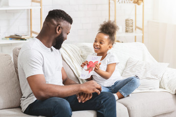 Obraz na płótnie Canvas Sweet little black girl holding greeting card for her dad