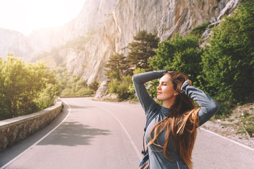Freedom traveler woman standing with raised arms and enjoying a beautiful nature
